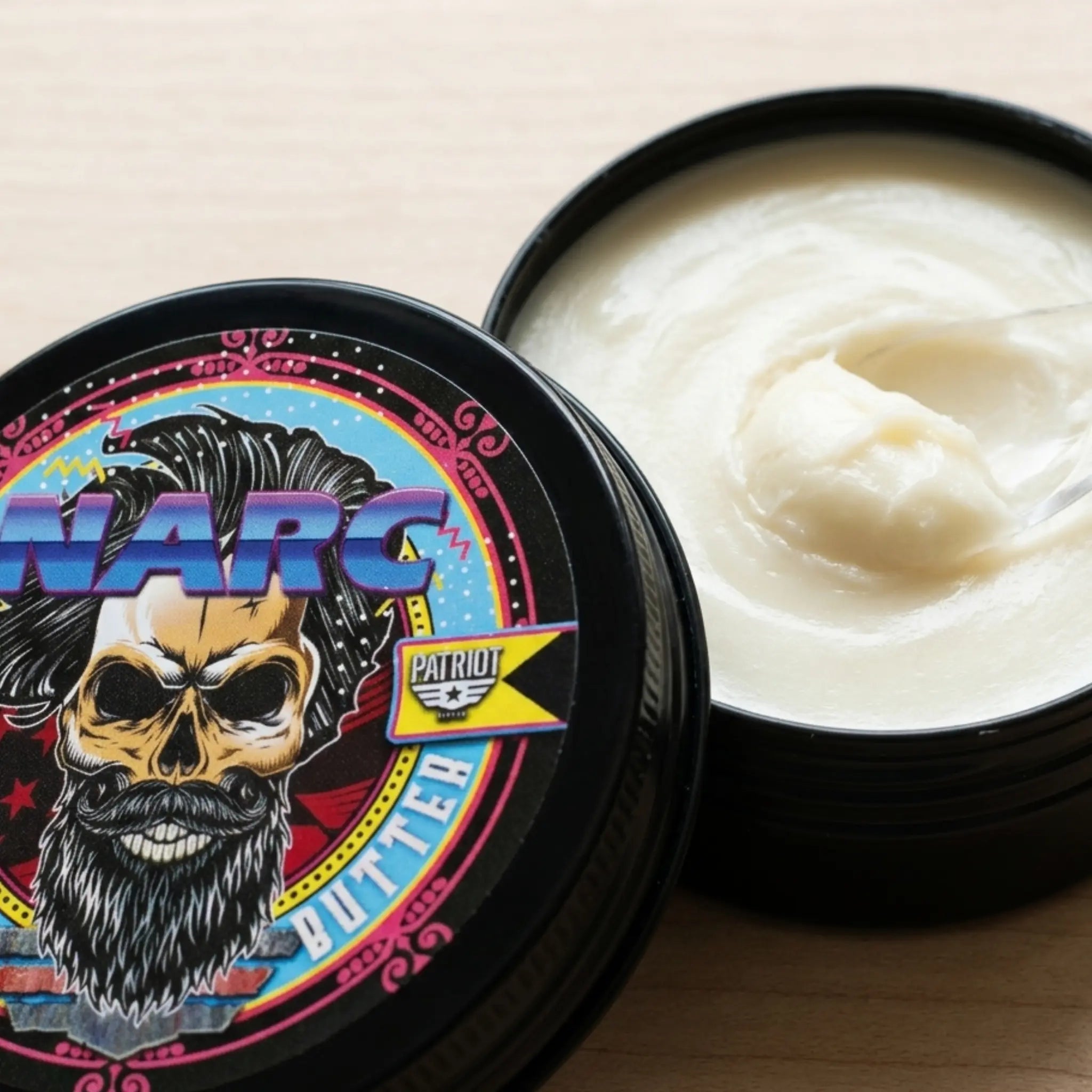 Macro view of the smooth, creamy texture of Flagship Soap Company’s NARC beard butter in an open 2 oz tin, highlighting the high-quality whipped consistency.