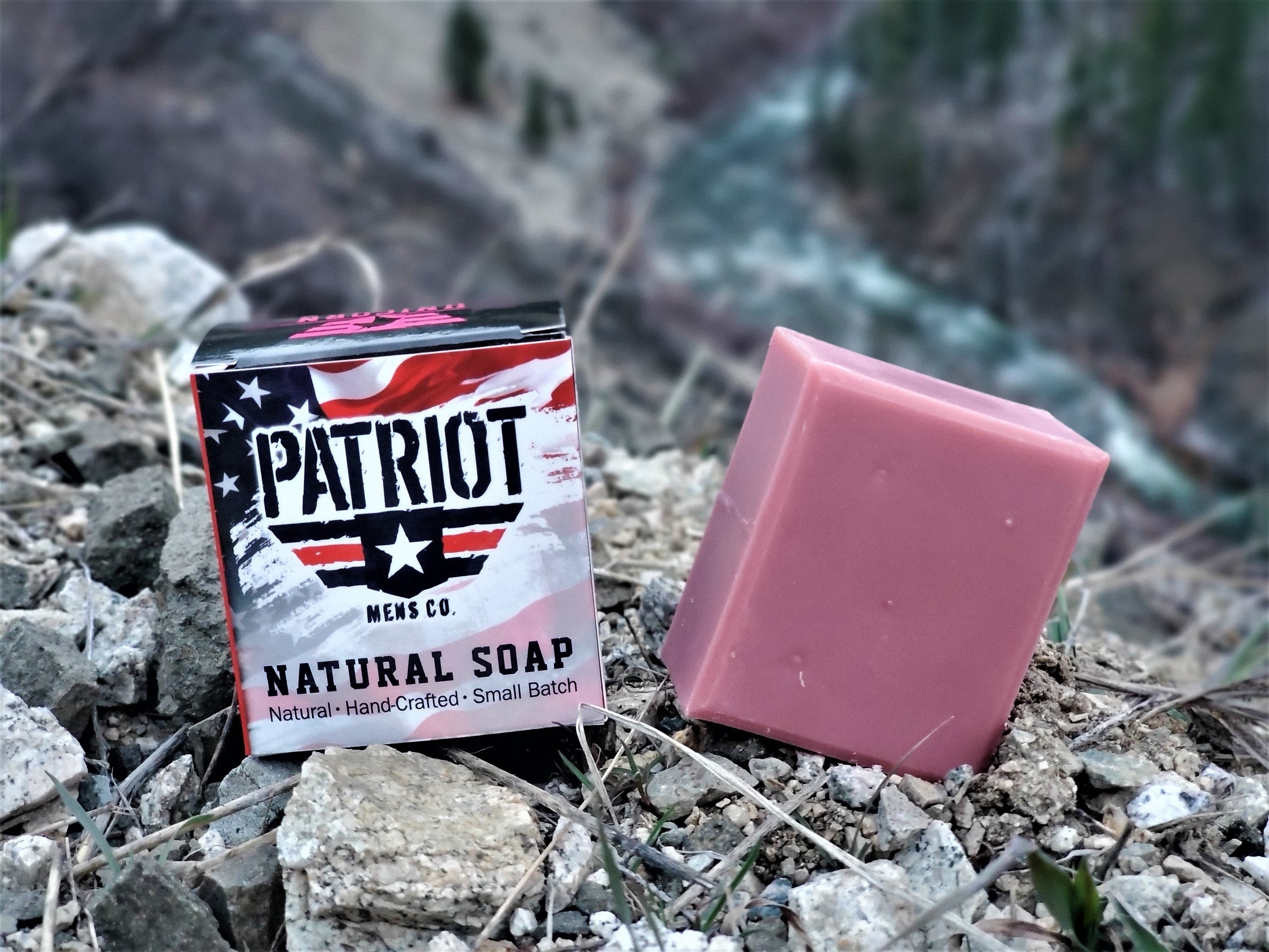 Unicorn natural men's soap with pink bar of soap in mountains of Idaho with river in background.  